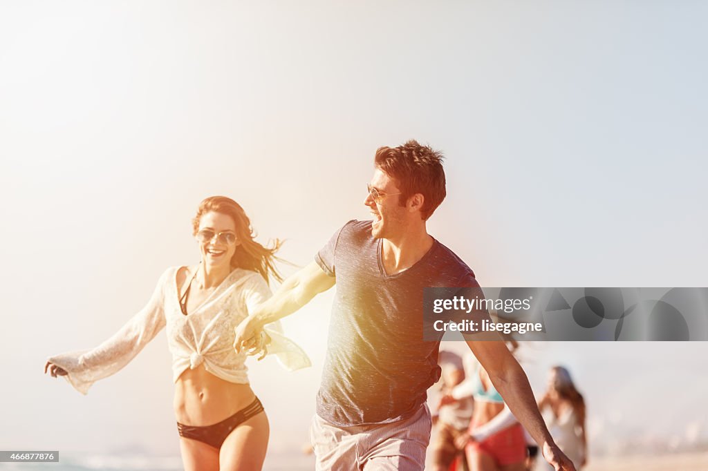 Grupo de amigos corriendo en la playa