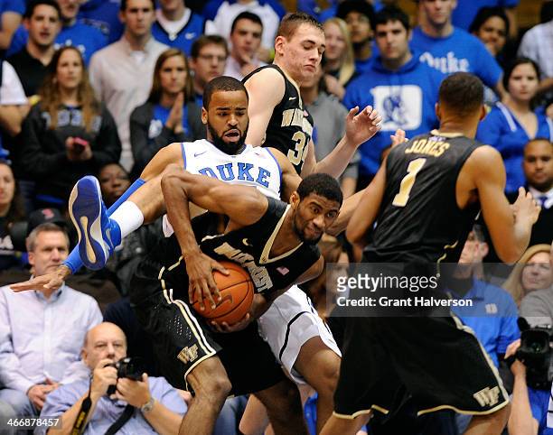 Josh Hairston of the Duke Blue Devils lands on Aaron Rountree III of the Wake Forest Demon Deacons as the battle for a rebound during their game at...