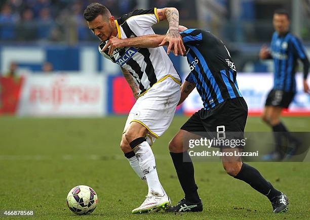 Cyril Thereau of Udinese Calcio is challenged by Giulio Migliaccio of Atalanta BC during the Serie A match between Atalanta BC and Udinese Calcio at...