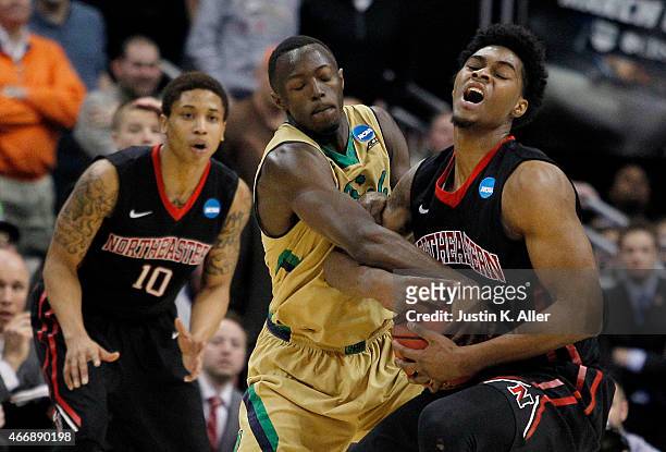 Jerian Grant of the Notre Dame Fighting Irish and Quincy Ford of the Northeastern Huskies vie for posession during the second round of the 2015 NCAA...