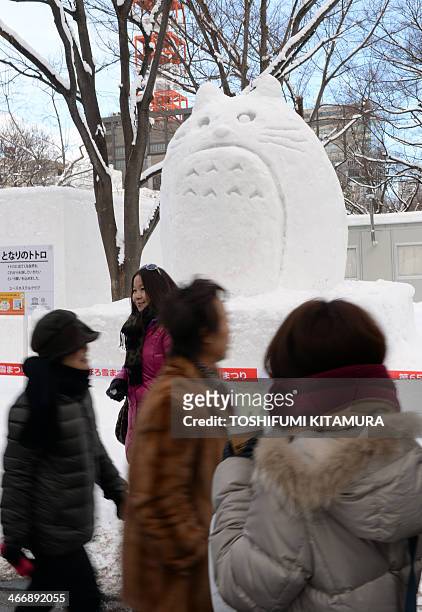 Tourists walk past snow statue entitled "My Neighbor Totoro" during the 65th annual Sapporo Snow Festival on February 5, 2014. The week-long festival...