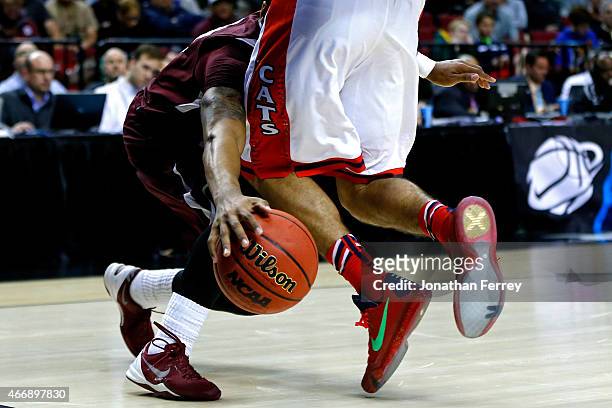Elliott Pitts of the Arizona Wildcats defends Madarious Gibbs of the Texas Southern Tigers in the second half during the second round of the 2015...