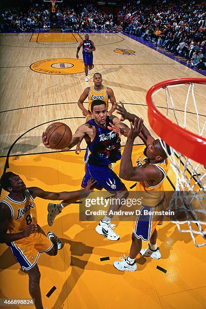 Damon Stoudamire of the Toronto Raptors shoots against Kobe Bryant of the Los Angeles Lakers on November 30, 1997 at The Forum in Inglewood,...