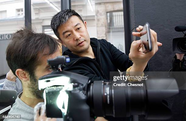 Chinese artist Liu Bolin takes a picture of his last artwork at the galerie Paris-Beijing on March 19, 2015 in Paris, France. Liu Bolin is...