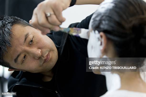 Chinese artist Liu Bolin takes part in a performance on March 19, 2015 in Paris. AFP PHOTO / KENZO TRIBOUILLARD RESTRICTED TO EDITORIAL USE,...