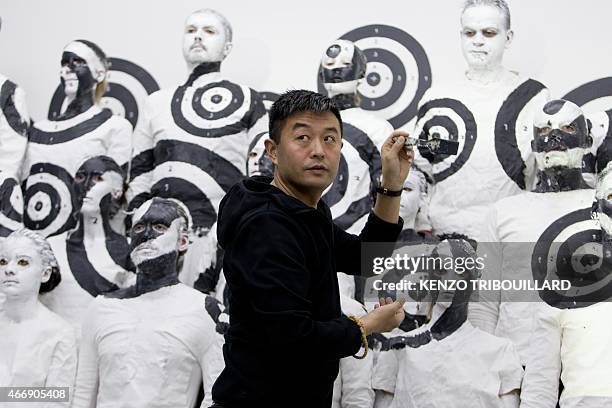 Chinese artist Liu Bolin takes part in a performance on March 19, 2015 in Paris. AFP PHOTO / KENZO TRIBOUILLARD RESTRICTED TO EDITORIAL USE,...