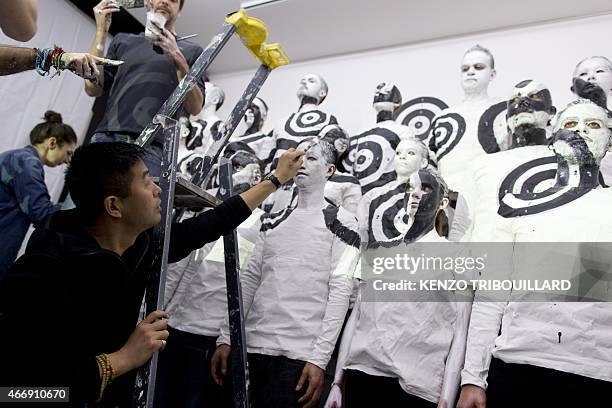 Chinese artist Liu Bolin takes part in a performance on March 19, 2015 in Paris. AFP PHOTO / KENZO TRIBOUILLARD == RESTRICTED TO EDITORIAL USE,...