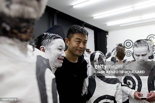 Chinese artist Liu Bolin takes part in a performance on March 19, 2015 in Paris. AFP PHOTO / KENZO TRIBOUILLARD == RESTRICTED TO EDITORIAL USE,...