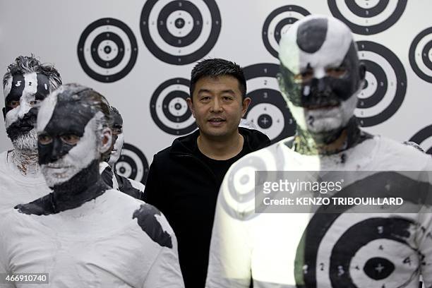 Chinese artist Liu Bolin takes part in a performance on March 19, 2015 in Paris. AFP PHOTO / KENZO TRIBOUILLARD == RESTRICTED TO EDITORIAL USE,...