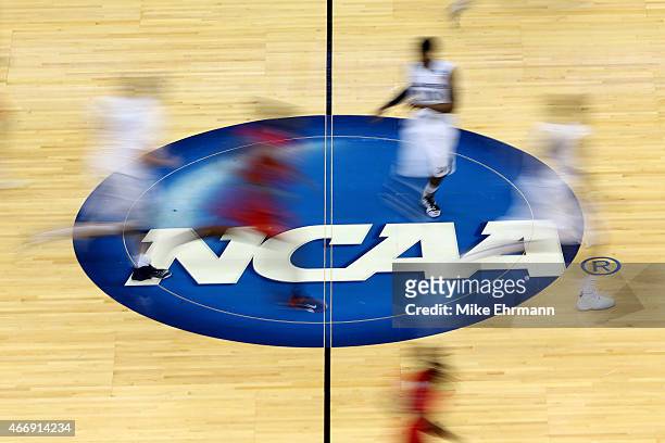 Mississippi Rebels and Xavier Musketeers players run by the logo at mid-court during the second round of the 2015 NCAA Men's Basketball Tournament at...