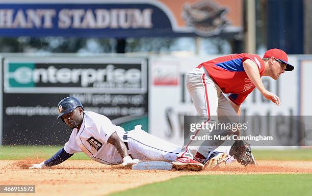 Xavier Avery of the Detroit Tigers slides head-first into second base ahead of the tag by Cord Phelps of the Philadelphia Phillies during the Spring...