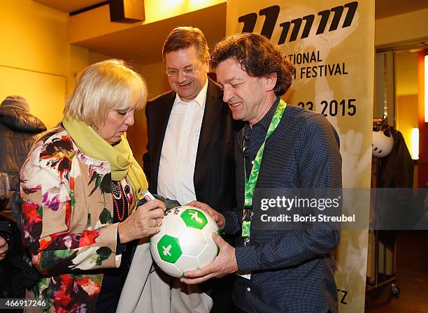 Politician Claudia Roth signs a ball of Jochen Lohmann of the 11mm festival prior to the German premiere of Messi - Der Film during the and 11MM Film...