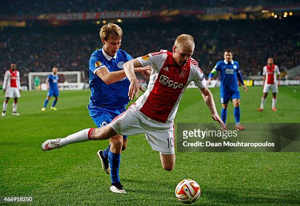 Davy Klaassen of Ajax goes down under the challenge from Roman Bezus of Dnipro during the UEFA Europa League Round of 16, second leg match between...