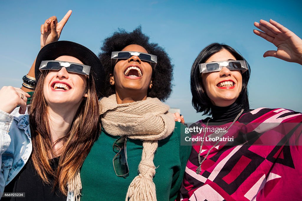 Group of friends looking to a solar eclipse