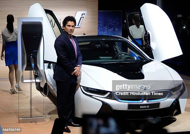 Indian cricketer Sachin Tendulkar poses with the BMW i8 Hybrid car during the 12th Auto Expo 2014 at India Expo Mart on February 5, 2014 in Greater...