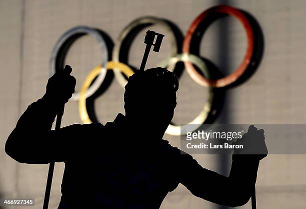 Biathlete passes the Olympic rings during a training session ahead of the Sochi 2014 Winter Olympics at the Laura Cross-Country Ski and Biathlon...