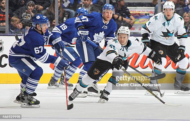 Daniil Tarasov of the San Jose Sharks skates to check Brandon Kozun of the Toronto Maple Leafs during an NHL game at the Air Canada Centre on March...