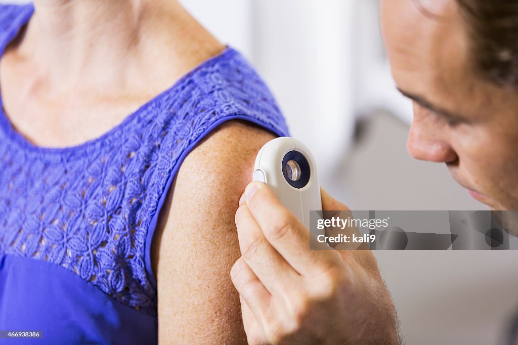 Dermatologist examining patient