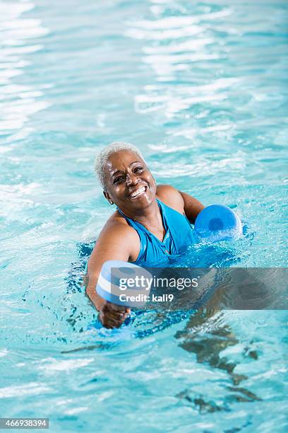 senior black woman exercising, doing water aerobics - african woman swimming stock pictures, royalty-free photos & images