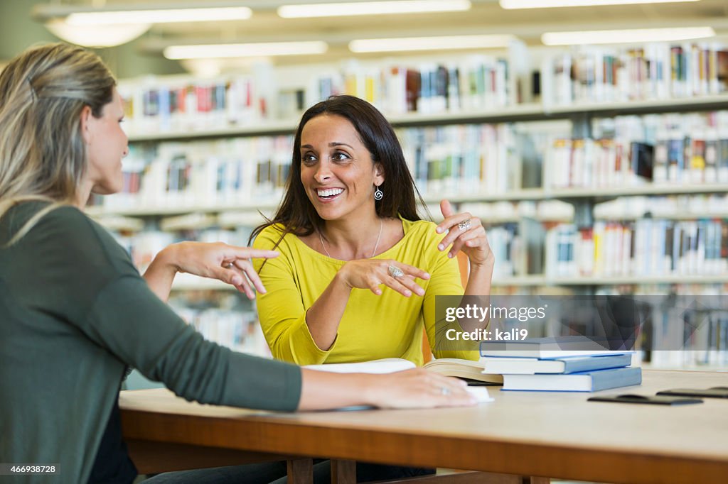 Adult students studying  together in library