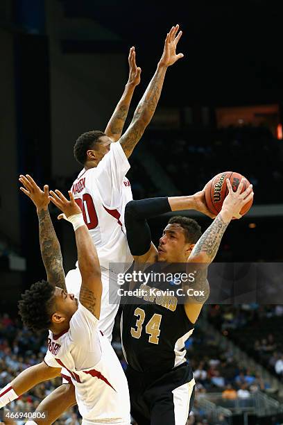 Anton Beard and teammate Rashad Madden of the Arkansas Razorbacks try to stop Lee Skinner of the Wofford Terriers during the second round of the 2015...