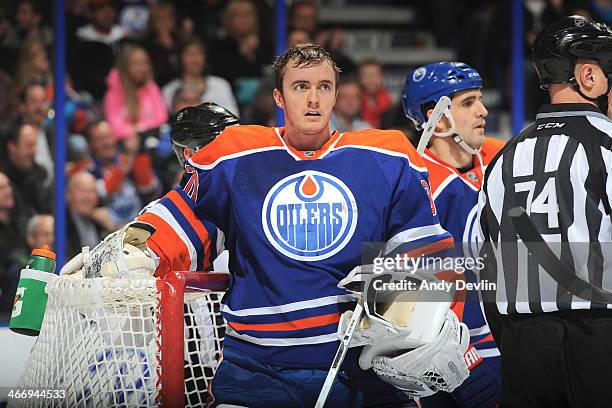 Ben Scrivens of the Edmonton Oilers removes his mask between play in a game against the San Jose Sharks on January 29, 2014 at Rexall Place in...