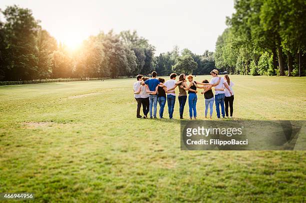 group of friends walking together - arm in arm stock pictures, royalty-free photos & images