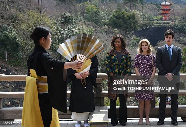 First Lady Michelle Obama , US Ambassador to Japan Caroline Kennedy and her son Jack Schlossberg watch a student perform a Noh play during a visit to...