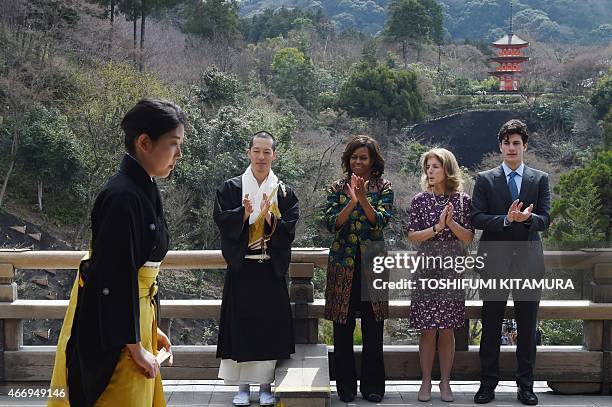 First Lady Michelle Obama , US Ambassador to Japan Caroline Kennedy and her son Jack Schlossberg applaud after a student performed a Noh play during...