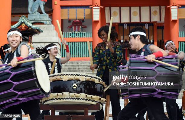 First Lady Michelle Obama plays the Taiko with Manaka Hirose and members of the Akutagawa high school Taiko Club while visiting the Fushimi Inari...