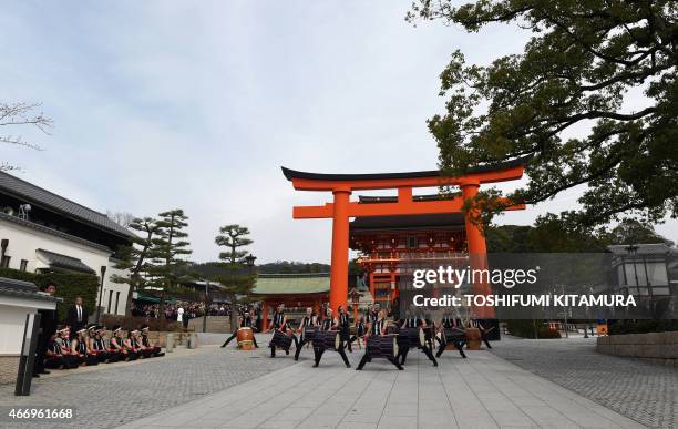 First Lady Michelle Obama and members of the Akutagawa high school Taiko Club perform the music at the Fushimi Inari shrine in Kyoto on March 20,...