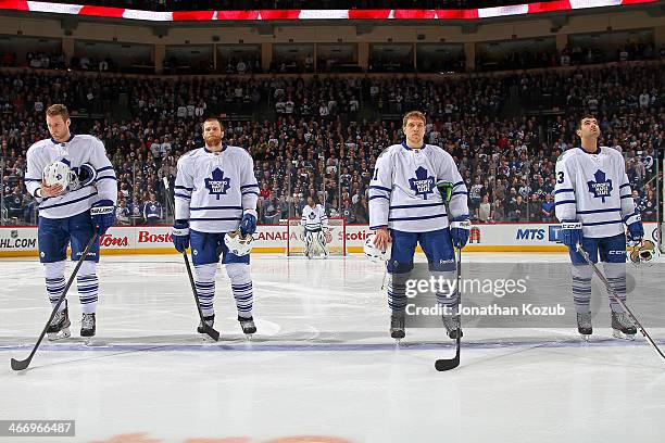 Cody Franson, Tim Gleason, Nikolai Kulemin and Nazem Kadri of the Toronto Maple Leafs stand on the ice during the singing of 'O Canada' prior to puck...