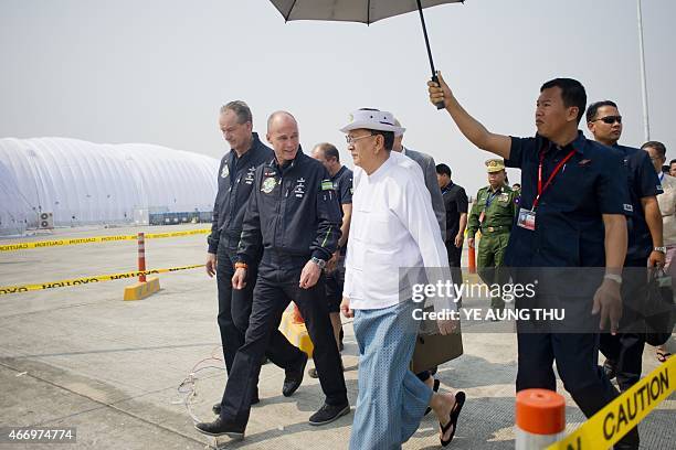 Myanmar president Thein Sein walk with Swiss pilots Andre Borschberg and Bertrand Piccard of Solar Impulse 2 at Mandalay international airport on...