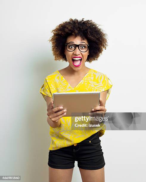 happy afro young using digital tablet - surprised woman looking at tablet stock pictures, royalty-free photos & images