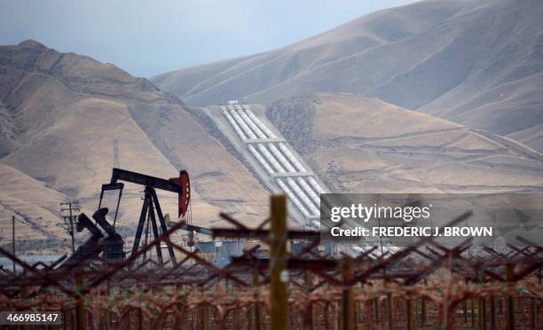 An oil derrick is seen near vineyards north of the Grapevine in central California's Kern County where the Chrisman Wind Gap Pumps, part of the...