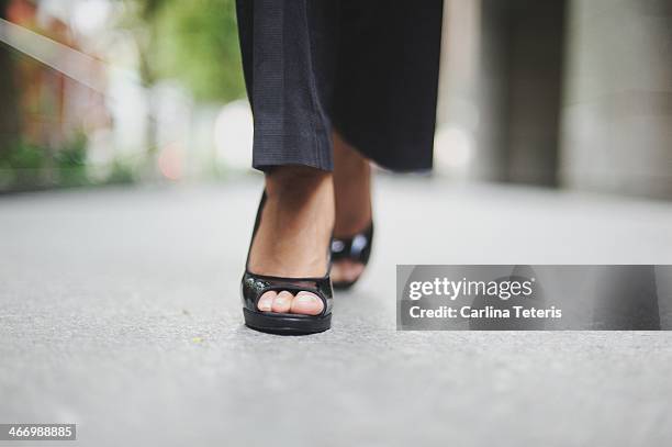 ground level view of a woman walking in heels - indian female feet foto e immagini stock