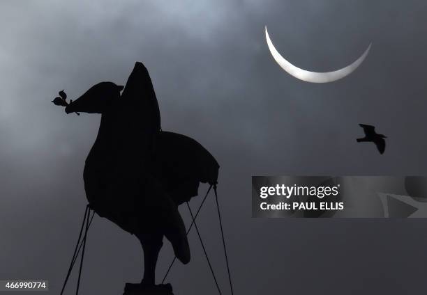 Partial solar eclipse of the sun is visible next to the iconic Liver Bird on top of the Liver Building in Liverpool, north-west England on March 20,...