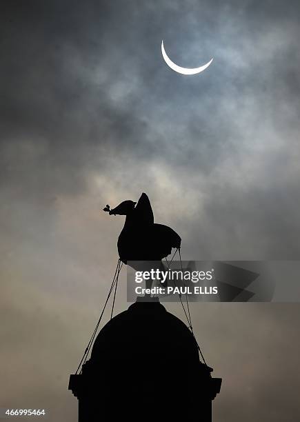 Partial solar eclipse of the sun is visible next to the iconic Liver Bird on top of the Liver Building in Liverpool, north-west England on March 20,...
