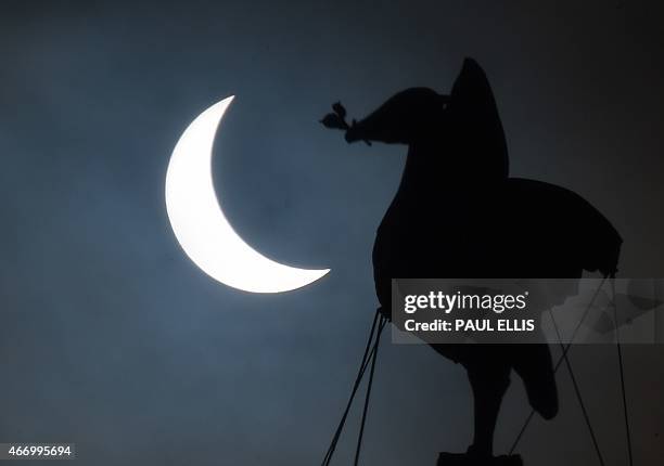 Partial solar eclipse of the sun is visible next to the iconic Liver Bird on top of the Liver Building in Liverpool, north-west England on March 20,...