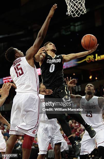 Askia Booker of the Colorado Buffaloes goes to the basket against Junior Longrus of the Washington State Cougars during the game at Spokane Arena on...