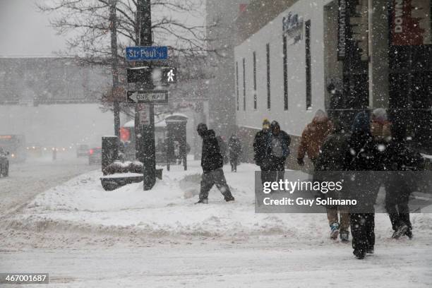 Pedestrians walk on Main Street during a snow storm on February 5, 2014 in Rochester, New York. An additional foot of snow blanketed Western New York...