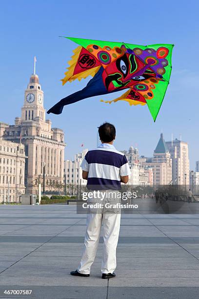 chinesischer mann spielt mit dragon drachen in shanghai, china - elderly chinese man stock-fotos und bilder