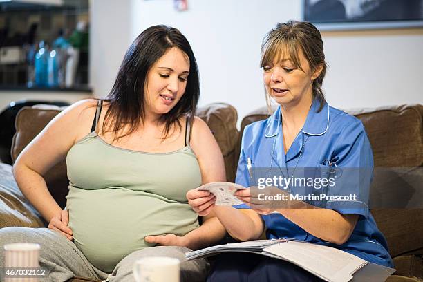 comadrona en su visita, el cálculo de fecha de vencimiento de los pacientes de bebé - comadrona fotografías e imágenes de stock