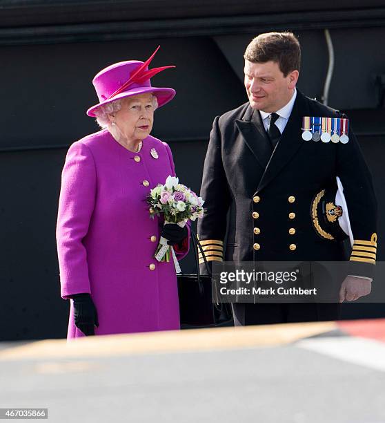 Captain Tim Henry escorts Queen Elizabeth II to the flight deck of HMS Ocean after an official visit on March 20, 2015 in Plymouth, England.