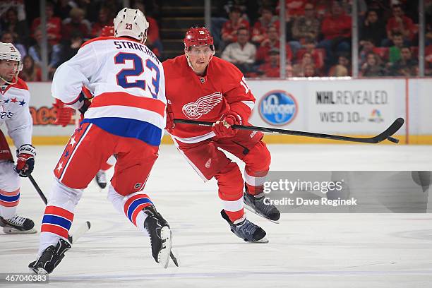 Joakim Andersson of the Detroit Red Wings dumps the puck past the defending Tyson Strachan of the Washington Capitals during an NHL game on January...