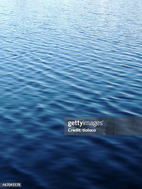 water peacefully rippling during the day - wateroppervlak stockfoto's en -beelden