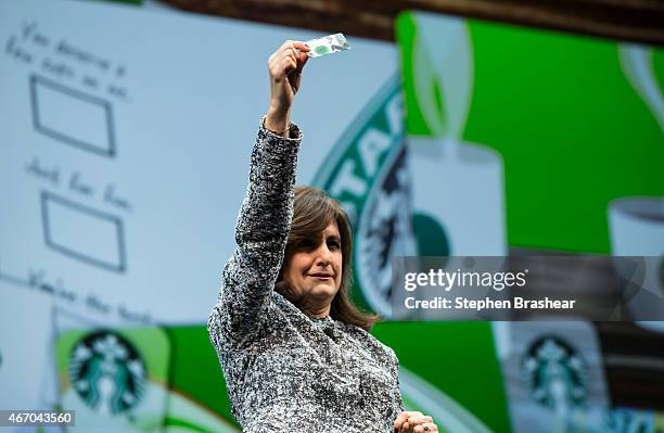 Starbucks chief marketing officer Sharon Rothstein holds up a gift card while speaking during the Starbucks annual shareholders meeting March 18,...