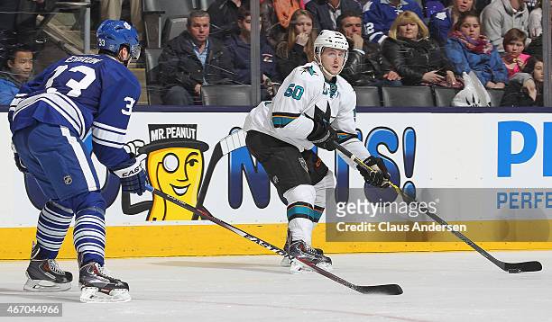 Chris Tierney of the San Jose Sharks looks to make a pass in front of Tim Erixon of the Toronto Maple Leafs during an NHL game at the Air Canada...