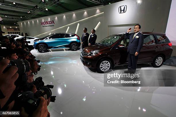 Takanobu Ito, president and chief executive officer of Honda Motor Co., right, poses with the company's Mobilio multi-purpose vehicle during a media...