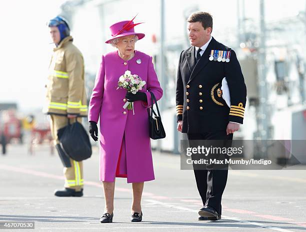 Queen Elizabeth II, accompanied by Captain Timothy Henry, stands on the flight deck of HMS Ocean before departing by helicopter, following a visit to...